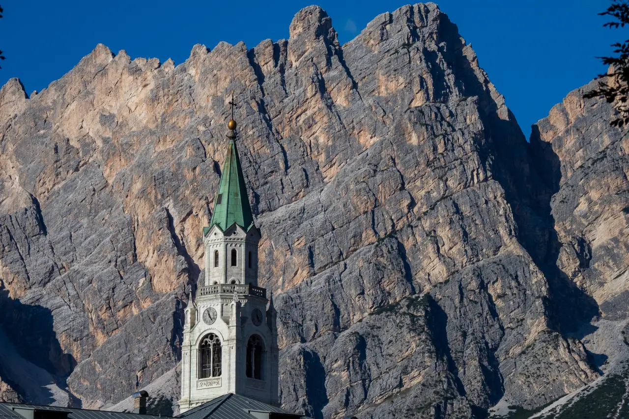 Il campanile di Cortina d'Ampezzo davanti alle vette delle Dolomiti