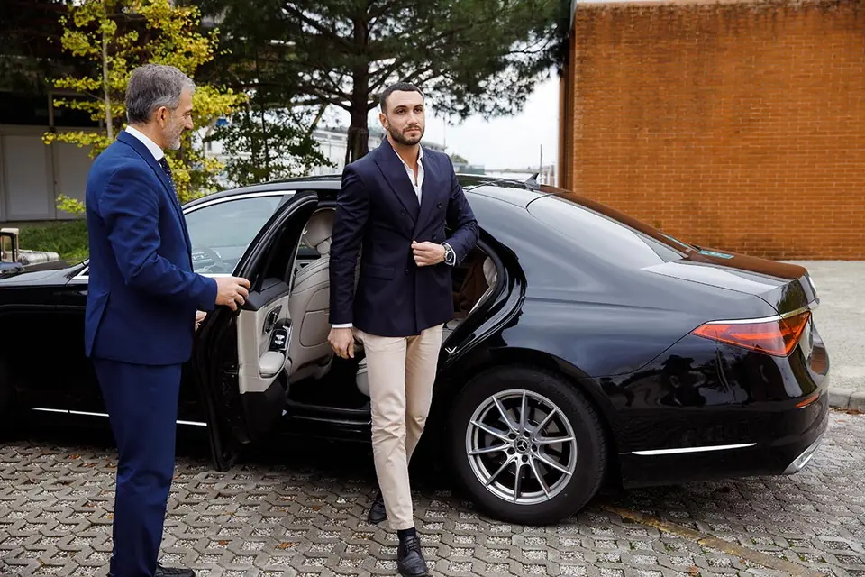 Autista VLS accanto a una Mercedes nera