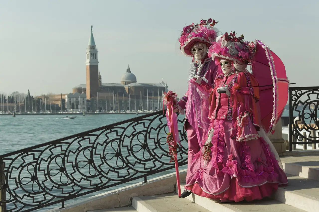 Maschere in costume di Carnevale davanti a San Giorgio Maggiore