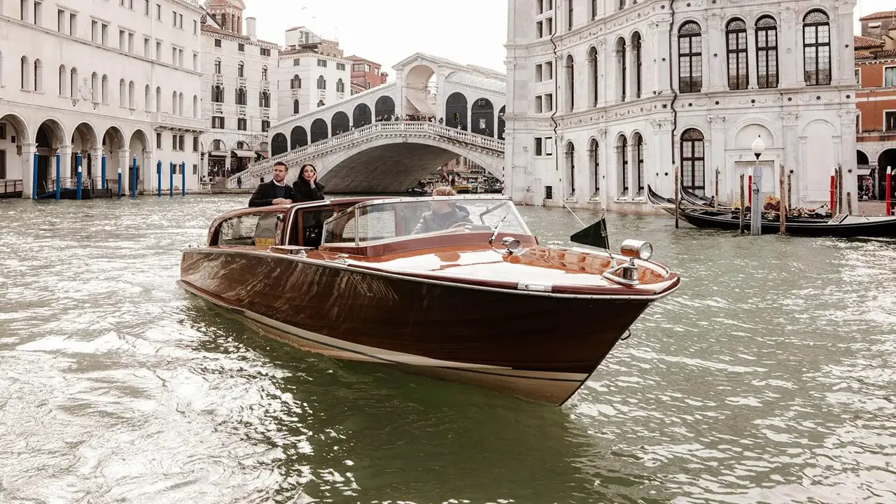 Ospiti su un taxi acqueo privato VLS davanti al Ponte di Rialto sul Canal Grande
